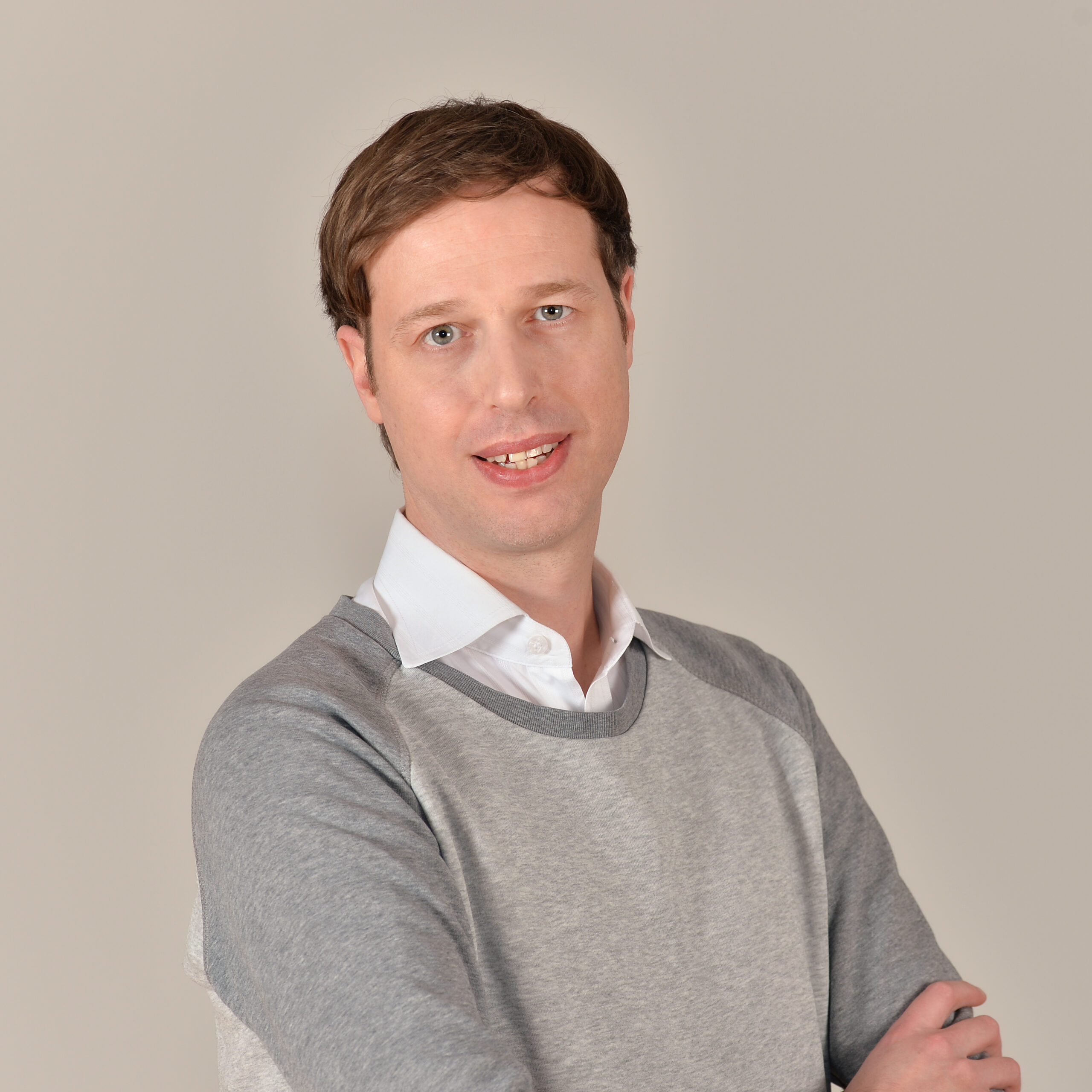 Profilbild von Jan Jacobi in weißem Hemd und grauem Pullover.